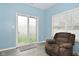 Bright living room features sliding glass doors, plush armchair, and wood grain flooring at 7527 Derek Dr, Camby, IN 46113