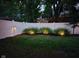 Backyard featuring a well-maintained lawn and a privacy fence, accented with landscape lighting enhancing its appeal at 7809 Bryden Dr, Fishers, IN 46038