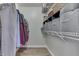 Walk-in closet with clothes hanging on one side and storage boxes on the shelves on the other at 855 Queensgate Dr, Greenwood, IN 46143