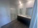 Bathroom with a double sink vanity, white countertop, and glass-enclosed shower at 8727 Duncan St, Fortville, IN 46040