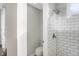 Bathroom showcasing white subway tile, a tiled shower and white toilet at 8807 Wintergreen Way, Indianapolis, IN 46256