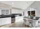 Bright kitchen with white cabinets, black countertops, and a convenient island with seating at 8807 Wintergreen Way, Indianapolis, IN 46256