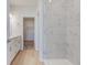 Modern bathroom featuring dual sinks, wood floors, and a marble-tiled shower at 9182 Mulligan Ct, Elwood, IN 46036
