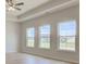 Bright bedroom with tray ceiling, three windows, and light wood floors at 9182 Mulligan Ct, Elwood, IN 46036