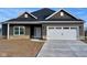 Charming single-story home featuring a modern garage, stone accents, and sleek gray siding at 9182 Mulligan Ct, Elwood, IN 46036