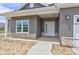 Close-up of the front porch with gray siding and a white front door with glass panes at 9182 Mulligan Ct, Elwood, IN 46036