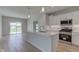Well-lit kitchen featuring an island and stainless steel appliances; with access to a dining area at 9182 Mulligan Ct, Elwood, IN 46036