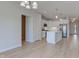Spacious open-concept living space with light wood floors leads to the kitchen area at 9182 Mulligan Ct, Elwood, IN 46036