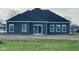 Back of the home with sleek, dark siding, a patio door, white trim, and large picture windows at 9182 Mulligan Ct, Elwood, IN 46036