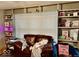 Living room showcasing built-in shelves, a sofa, and a window with blinds at 921 W Carson St, Muncie, IN 47303