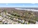 An aerial view of a residential neighborhood with mature trees and a lake in the background on a bright day at 10221 Tournon Dr, Fishers, IN 46037