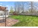 Landscaped backyard with patio area, swing set, and privacy fence at 10221 Tournon Dr, Fishers, IN 46037