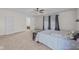 Sun-filled bedroom boasts neutral carpet, ceiling fan, a queen bed, and a built-in bookcase at 10221 Tournon Dr, Fishers, IN 46037