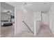 Bright hallway with carpet, white walls, a staircase, and entry into a bedroom with ceiling fan at 10221 Tournon Dr, Fishers, IN 46037