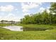 Scenic view of a serene community pond surrounded by lush greenery and well-manicured lawns at 1024 Cyprian Way, Lebanon, IN 46052