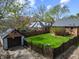 A fully fenced backyard features a detached garage and mature trees creating privacy at 1025 E 60Th St, Indianapolis, IN 46220