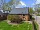 A fully fenced backyard features a green lawn with mature trees surrounding the property at 1025 E 60Th St, Indianapolis, IN 46220