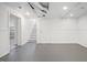 Unfinished basement space with painted floors, storage, and a view into a finished area at 1025 E 60Th St, Indianapolis, IN 46220