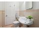 Charming bathroom featuring a pedestal sink, a toilet, and retro pink and white tile at 1025 E 60Th St, Indianapolis, IN 46220