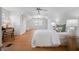 Bright bedroom featuring hardwood floors, a ceiling fan, and a glimpse into the hallway at 1025 E 60Th St, Indianapolis, IN 46220