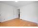 Empty room with hardwood floors, a centered ceiling light fixture, and a doorway at 1025 E 60Th St, Indianapolis, IN 46220