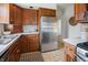 Traditional kitchen with stainless steel refrigerator, wood cabinetry, and patterned tile floor at 1025 E 60Th St, Indianapolis, IN 46220