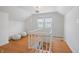 Bright open living room with hardwood floors and two white pouf chairs near the staircase at 1025 E 60Th St, Indianapolis, IN 46220