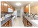 Galley-style kitchen features wooden cabinetry, white appliances and spacious countertops at 1044 Timber Creek Dr # 4, Carmel, IN 46032