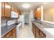Galley kitchen with full appliances, ample cabinet storage, and view of laundry room at 1044 Timber Creek Dr # 4, Carmel, IN 46032
