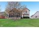 Beautiful backyard view highlighting the screened-in porch, lawn, and mature trees at 10934 Haig Point Dr, Fishers, IN 46037