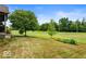 Picturesque backyard featuring lush lawn and mature trees, offering a tranquil outdoor space at 10934 Haig Point Dr, Fishers, IN 46037