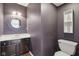 Stylish half bathroom with a dark vanity and decorative mirror at 10934 Haig Point Dr, Fishers, IN 46037