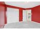 Bedroom featuring plush carpeting, closet storage, and bright red accent walls at 10934 Haig Point Dr, Fishers, IN 46037