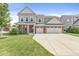 Charming two-story home with a three-car garage, manicured lawn, and inviting front porch at 11003 Liberation Trce, Noblesville, IN 46060