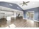 Open concept living room featuring an island kitchen, sliding glass doors to a patio, and staircase at 11003 Liberation Trce, Noblesville, IN 46060