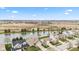 Picturesque aerial scene with houses bordering a pond, construction site beyond, and tree-lined streets at 11182 Black Gold Dr, Noblesville, IN 46060