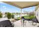 Covered back porch overlooking pond with grill, seating, and patio furniture at 11182 Black Gold Dr, Noblesville, IN 46060