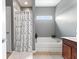 Bathroom features a tub with window and a shower with a floral curtain at 11182 Black Gold Dr, Noblesville, IN 46060