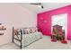 Bright bedroom with a daybed, pink walls, and an assortment of colorful decorations and dollhouse at 11182 Black Gold Dr, Noblesville, IN 46060