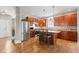 Well-lit kitchen with stainless steel appliances, an island with seating, and hardwood floors at 11182 Black Gold Dr, Noblesville, IN 46060