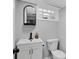 Modern half bathroom with white fixtures, black hardware, and a glass block window at 1139 E 35Th St, Indianapolis, IN 46205