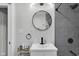 Modern bathroom featuring a sleek vanity with round mirror and tiled shower with black hardware at 1139 E 35Th St, Indianapolis, IN 46205