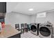 Bright laundry room with modern appliances, including a new washer and dryer, and three black chairs at 1139 E 35Th St, Indianapolis, IN 46205