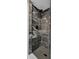 Close-up of a stylish shower with marble-patterned tiles, matte black hardware, and a mosaic-tiled floor at 1139 E 35Th St, Indianapolis, IN 46205