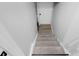 Stairwell leading down to a basement, featuring carpeted steps and a white door at the bottom at 1139 E 35Th St, Indianapolis, IN 46205