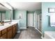 Bathroom featuring wood cabinets, double vanity, large mirrors, and tiled flooring at 11958 Logan Hunter Trl, Noblesville, IN 46060