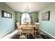 Inviting dining room with a wooden table, six chairs, large windows, and stylish green walls at 11958 Logan Hunter Trl, Noblesville, IN 46060
