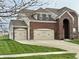 Charming brick two-story home boasts an attached three-car garage and a well-manicured front lawn at 11958 Logan Hunter Trl, Noblesville, IN 46060