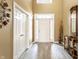 Bright foyer featuring a front door with sidelights, gray wood-look tile flooring, and stylish decor at 11958 Logan Hunter Trl, Noblesville, IN 46060