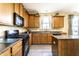 Well-lit kitchen featuring wood cabinets, an island, and modern appliances for cooking and entertaining at 11958 Logan Hunter Trl, Noblesville, IN 46060